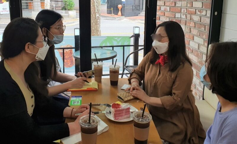 レストランのテーブルに座っている女性たち 自動的に生成された説明